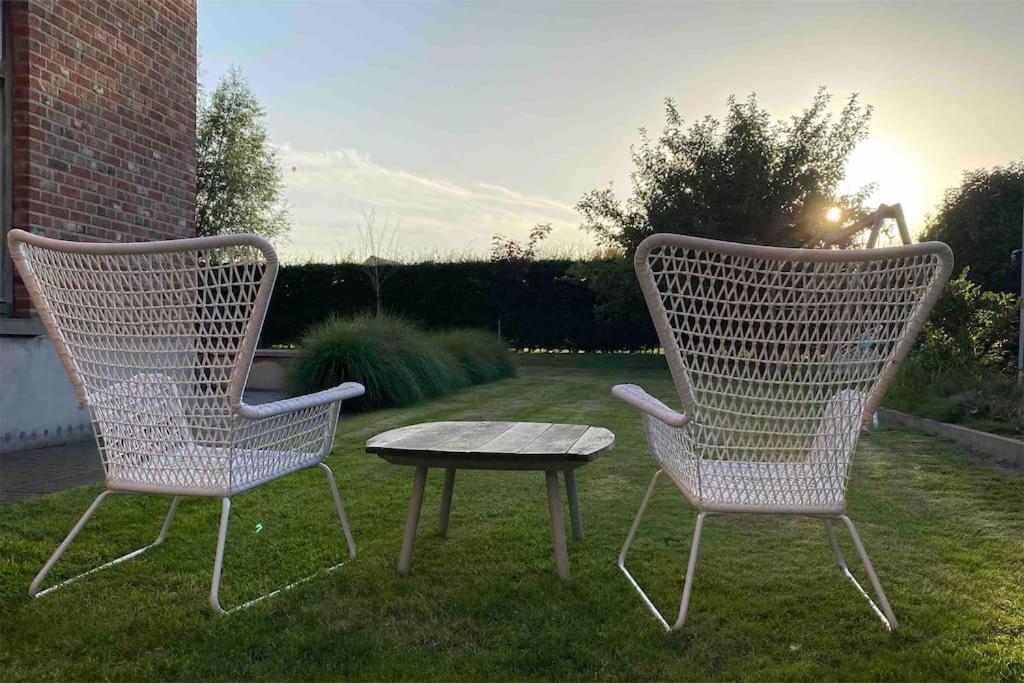 twee stoelen en een tafel in de tuin bij The Conservatory in Lokeren