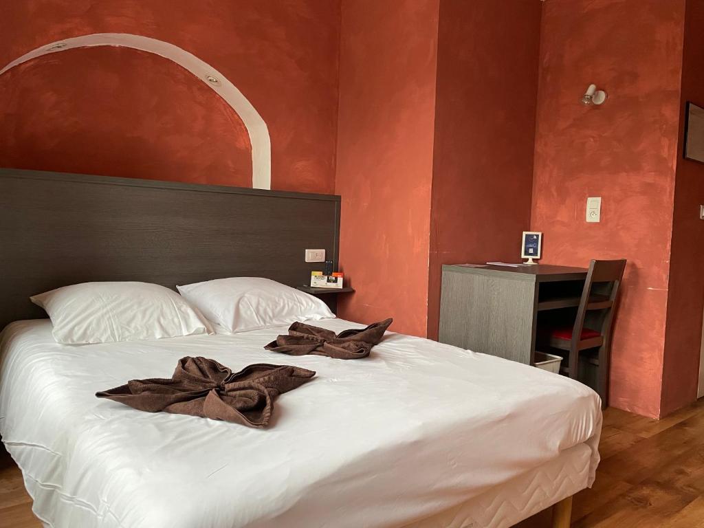 Un dormitorio con una cama con arcos marrones. en Maison Galland, en Lapalisse