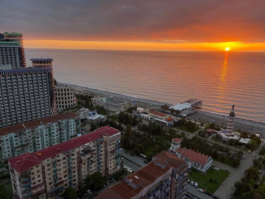 an aerial view of a city and the ocean at sunset at Orbi city Panorama towers in Batumi