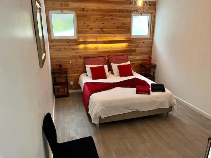 a bedroom with a large bed with red pillows at Caloura Fire Accommodation in Lagoa
