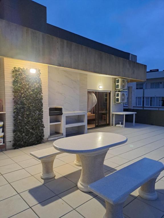 a table and two benches on a patio at apartamento perto do Santuário in Fátima
