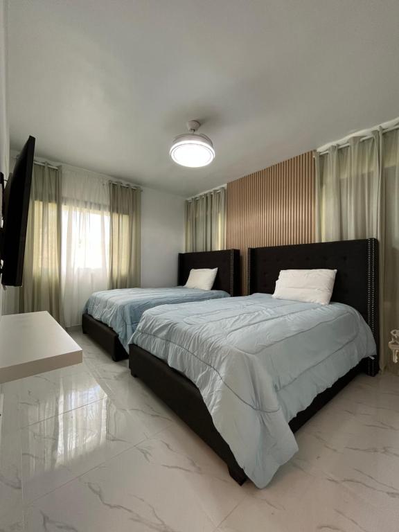 a bedroom with two beds and a lamp at Apartamento Cadaques Bayahibe in Mata Chalupe