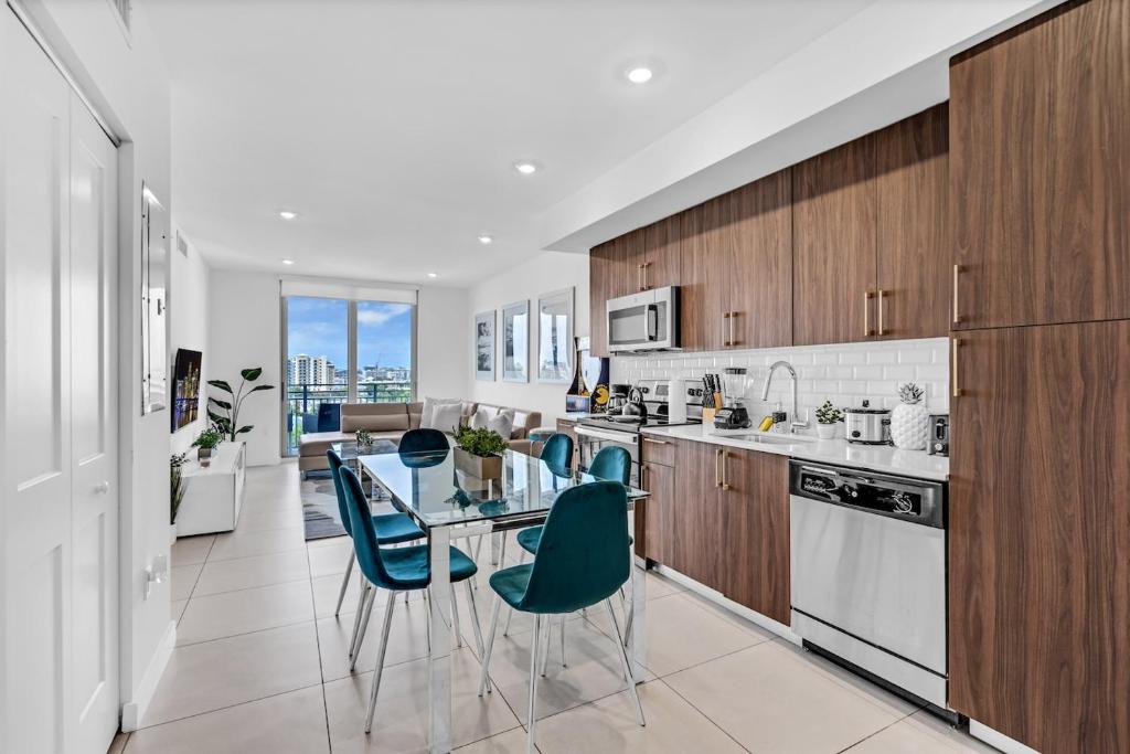 een keuken met een glazen tafel en blauwe stoelen bij Chic 3 Bed Retreat Mins Brickell With Free Parking in Miami