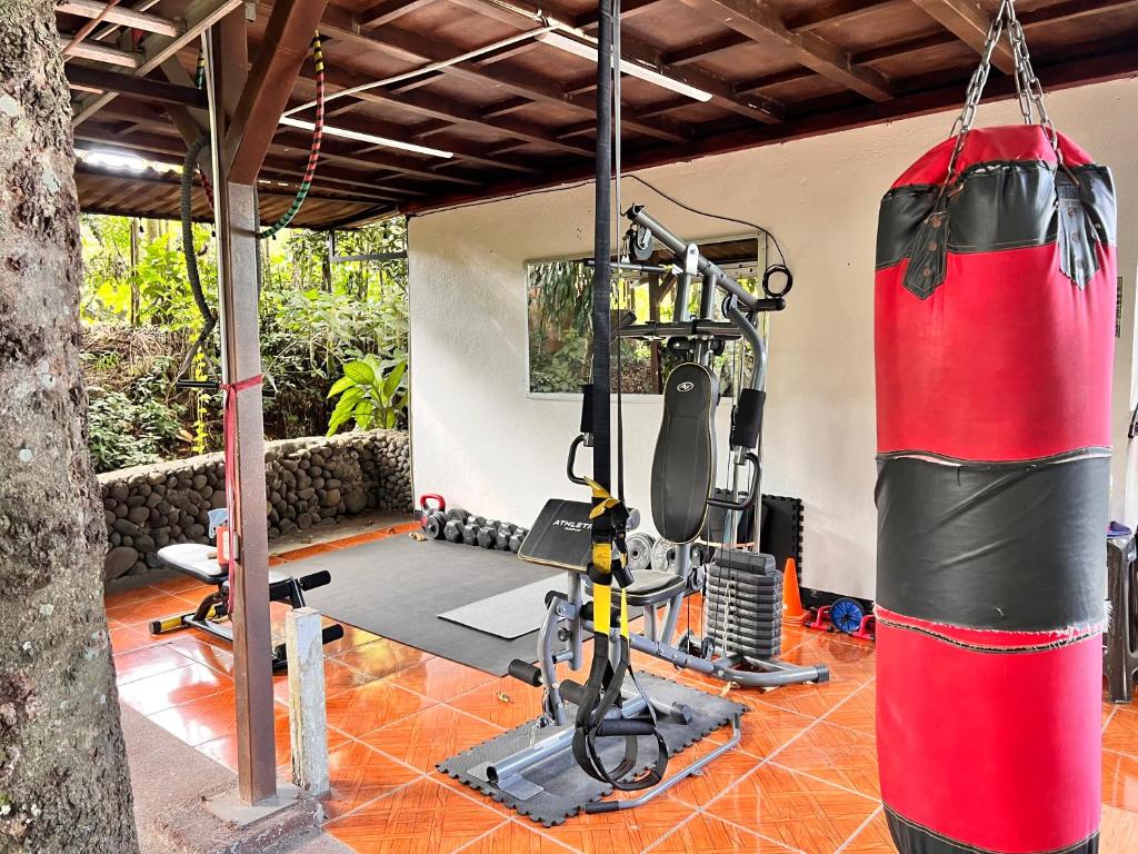 un gimnasio con un saco de boxeo junto a un gimnasio en Rio Danta Hostel, en Fortuna