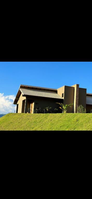 una casa sentada en la cima de un exuberante campo verde en Chalés W, en Jacutinga