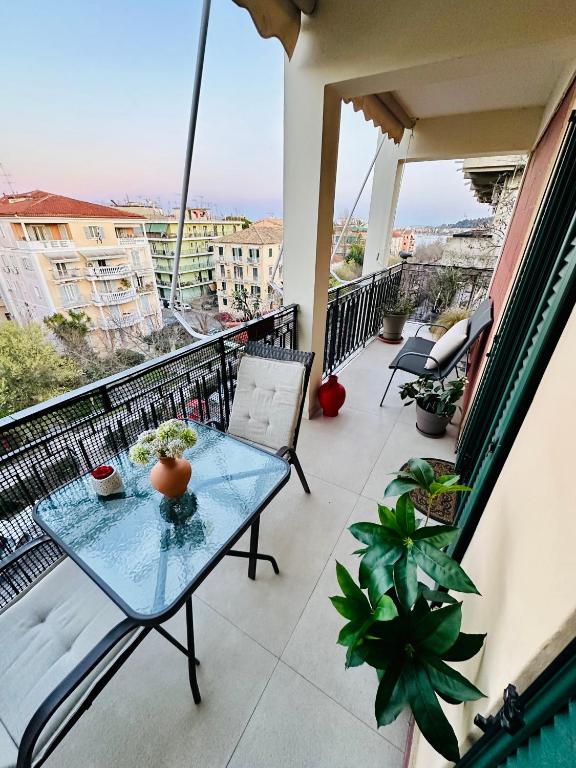 a balcony with a glass table and chairs on it at Elli & Klairi Apartment in Ágios Rókkos
