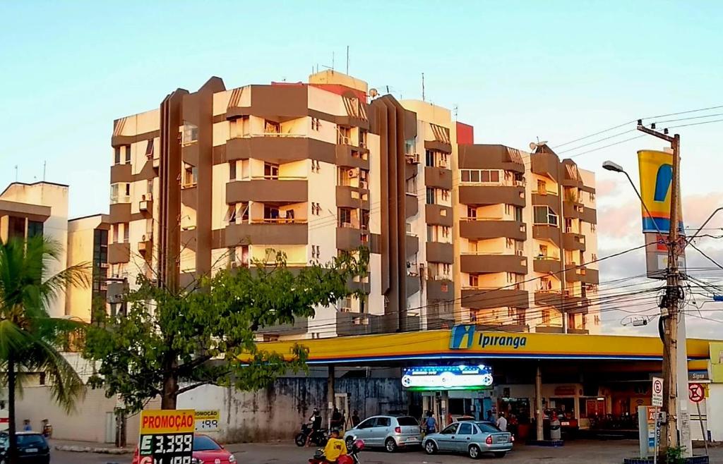 um edifício alto com carros estacionados em frente em Flat Central do Martins em São Luís