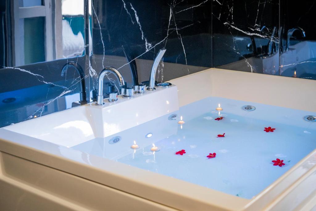 a bath tub with a sink with candles in it at Exclusive with Jacuzzi between Portofino and 5 Terre in Chiavari