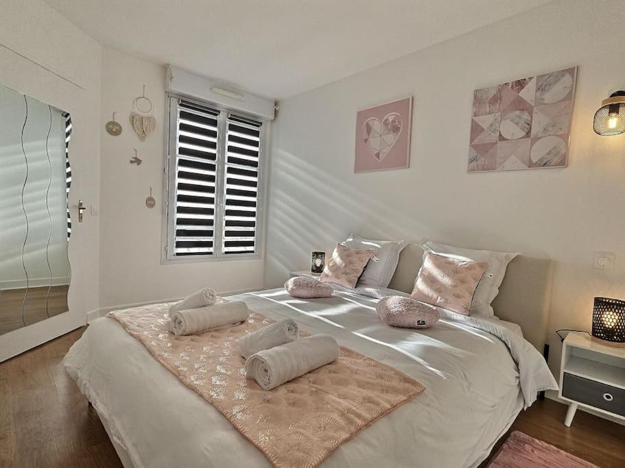 ein Schlafzimmer mit einem großen Bett mit Kissen darauf in der Unterkunft Le Bonheur Charmant *Disney*Paris*RER A* in Bussy-Saint-Georges