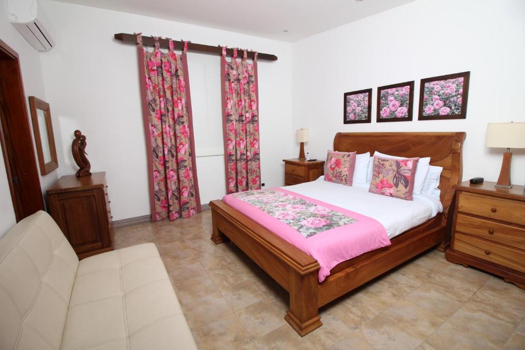 a bedroom with a bed and a couch and curtains at Amazilia Hotel in Pereira