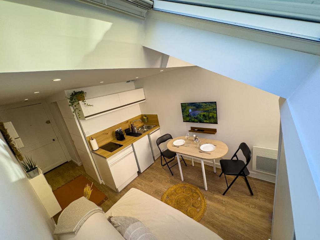 un salon avec une table et une cuisine dans l'établissement Le petit Jean - Studio hyper centre, à Grenoble