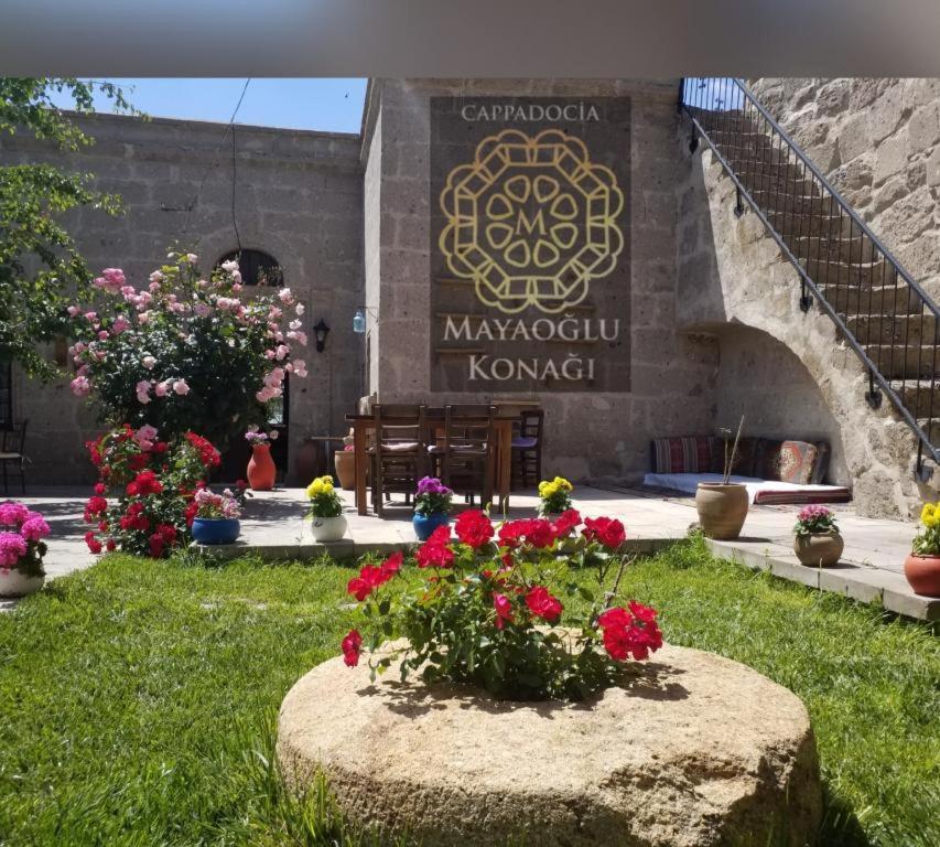 einen Garten mit Blumen vor einem Gebäude in der Unterkunft Mayaoglu Konagi Hotel in Guzelyurt
