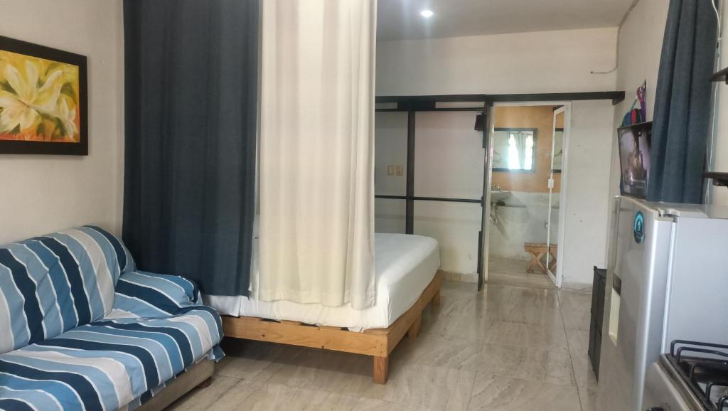 een woonkamer met een bank en een raam bij Casa B&V in Isla Mujeres