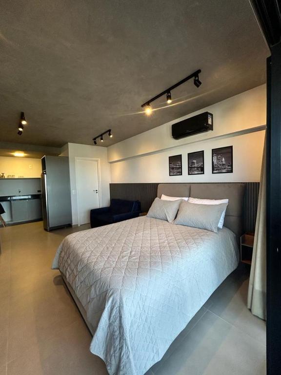 1 dormitorio con 1 cama blanca grande en una habitación en Studio 905, en Marília