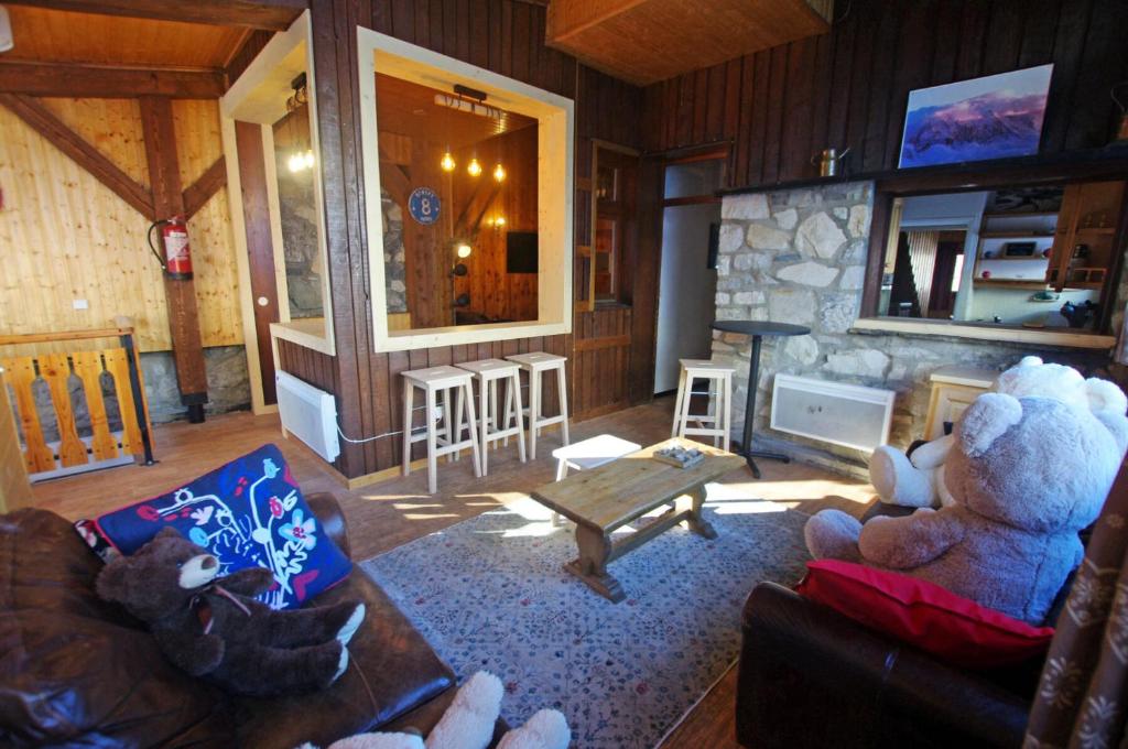 a living room with a teddy bear sitting on a couch at Chalet Pre Saint-jacques - Chalets pour 15 Personnes 601 in Tignes