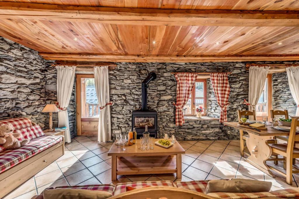 a living room with a couch and a stove at Chalet Les Champs Du Pont - Chalets pour 15 Personnes 591 in Tignes