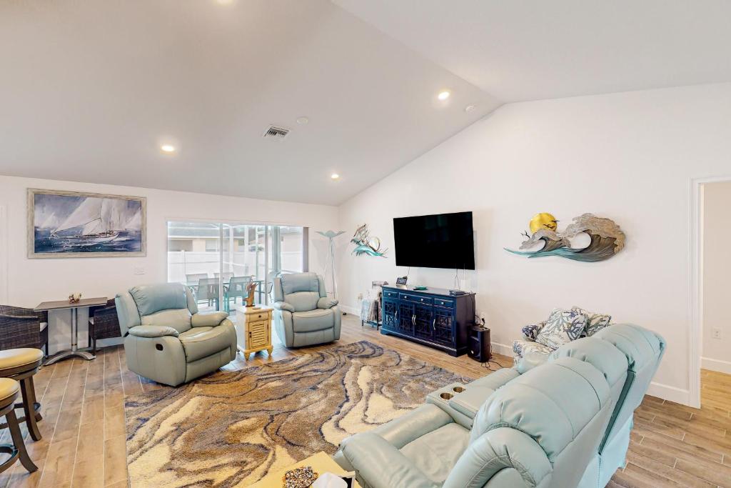 sala de estar con sofás azules y TV de pantalla plana en Blissful Retreat, en North Port