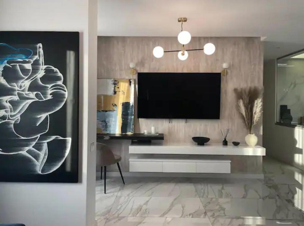 a living room with a flat screen tv on a wall at Penthouse Împăratul Traian in Craiova