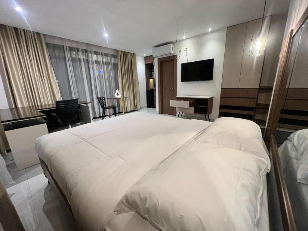 a bedroom with a large white bed and a desk at NOVAPARK FERROVIARIA in Guayaquil