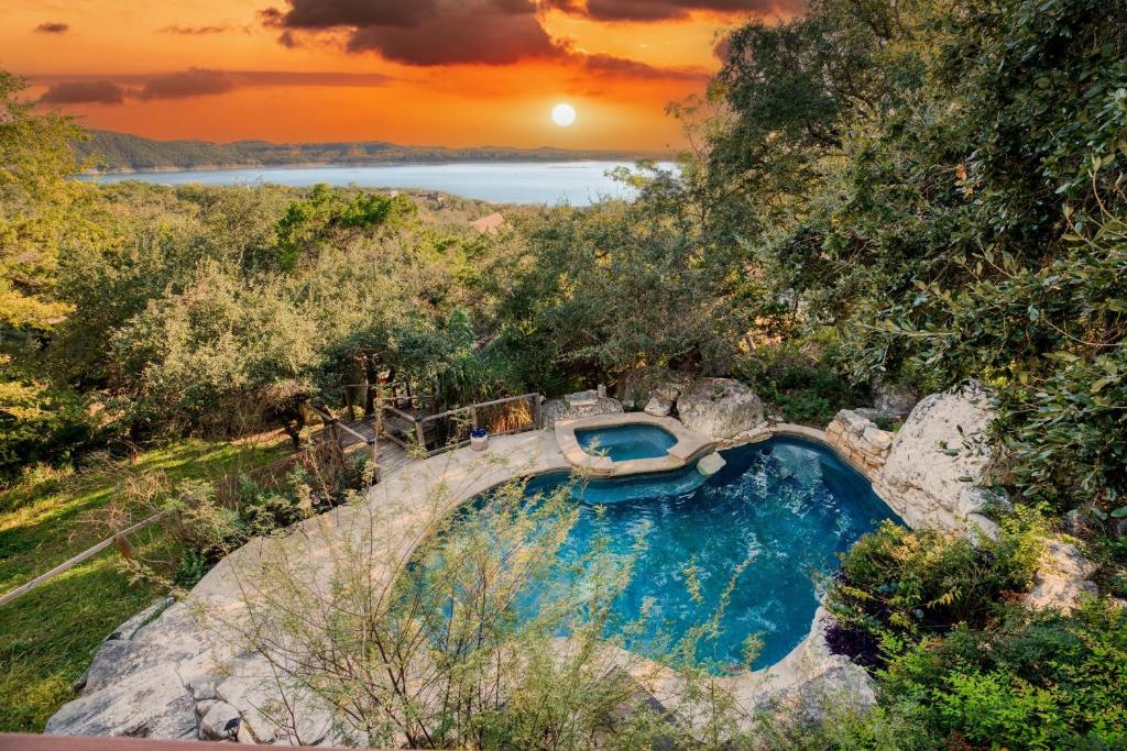 un bain à remous sur une colline avec un coucher de soleil en arrière-plan dans l'établissement Dawson by AvantStay Serene Austin Home set Amongst nature w Pool Hot Tub Close to Lake Travis, à Austin