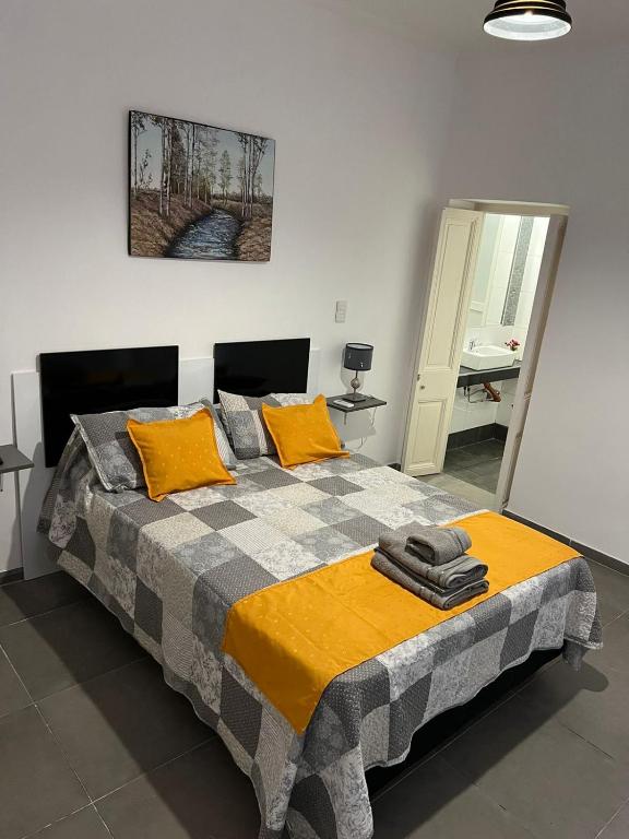 a bedroom with a large bed with yellow pillows at Departamento Mis Nonos 3 in Mendoza