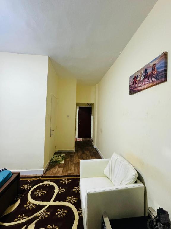 Dream Studio Room/Abu-Dhabi في أبوظبي: غرفة معيشة مع أريكة بيضاء وسجادة
