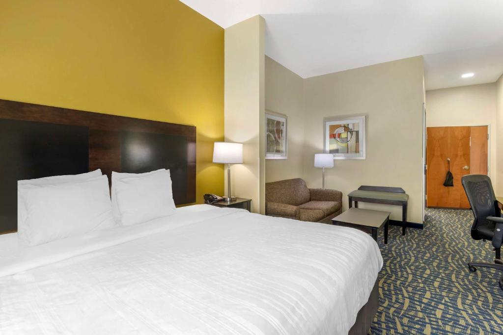 a hotel room with a large bed and a chair at Best Western Plus Brunswick Inn & Suites in Brunswick