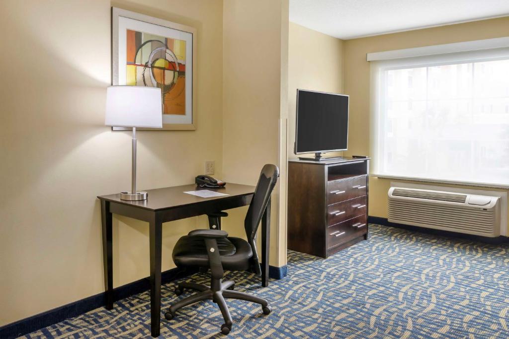 a room with a desk with a computer and a television at Best Western Plus Brunswick Inn & Suites in Brunswick