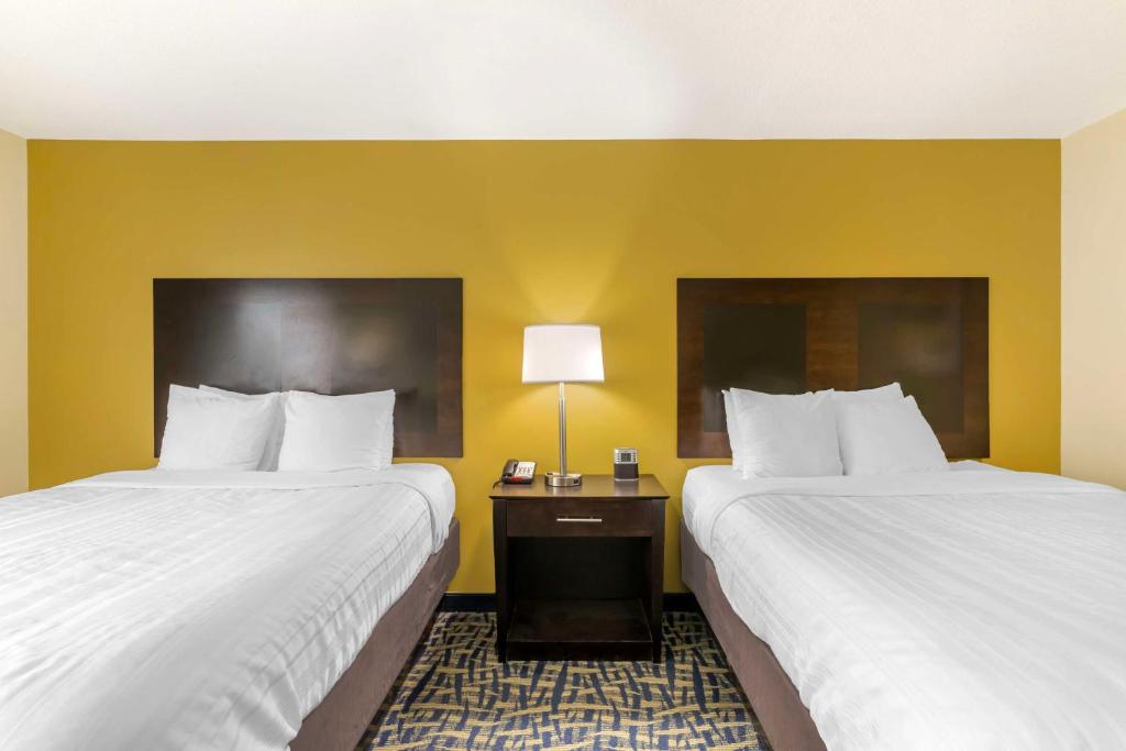 two beds in a hotel room with yellow walls at Best Western Plus Brunswick Inn & Suites in Brunswick