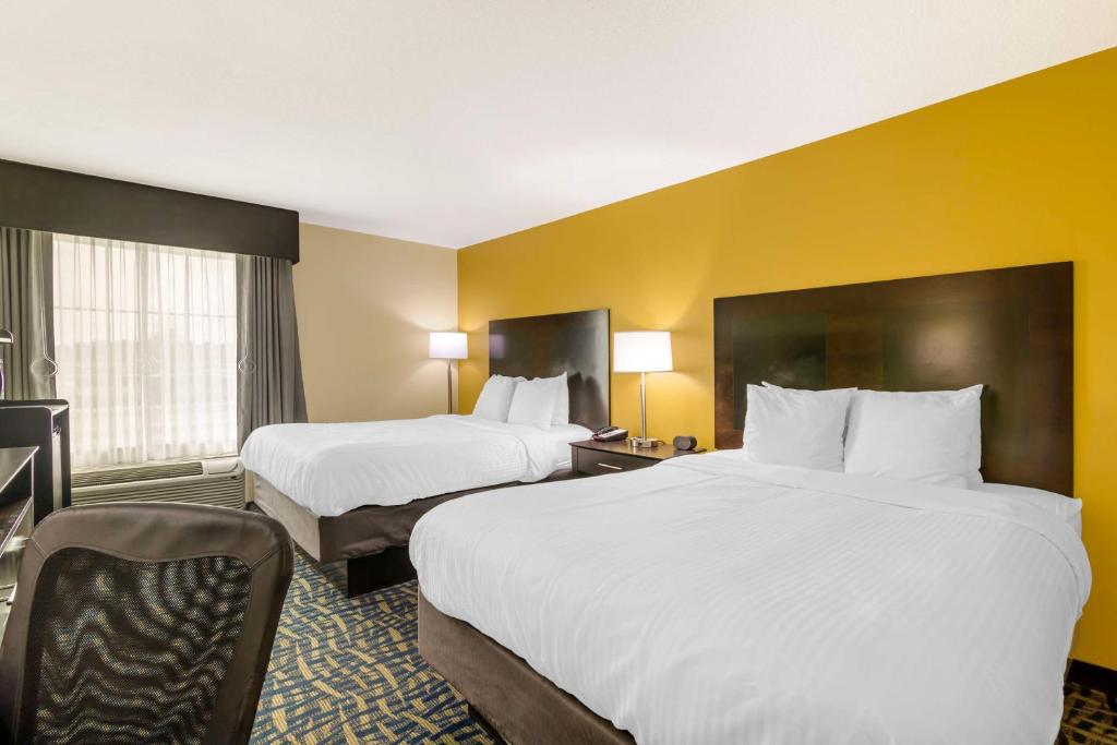 two beds in a hotel room with yellow walls at Best Western Plus Brunswick Inn & Suites in Brunswick