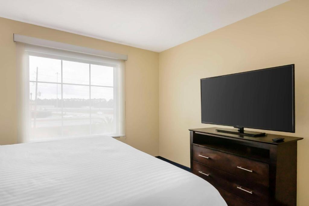 a bedroom with a bed and a flat screen tv at Best Western Plus Brunswick Inn & Suites in Brunswick