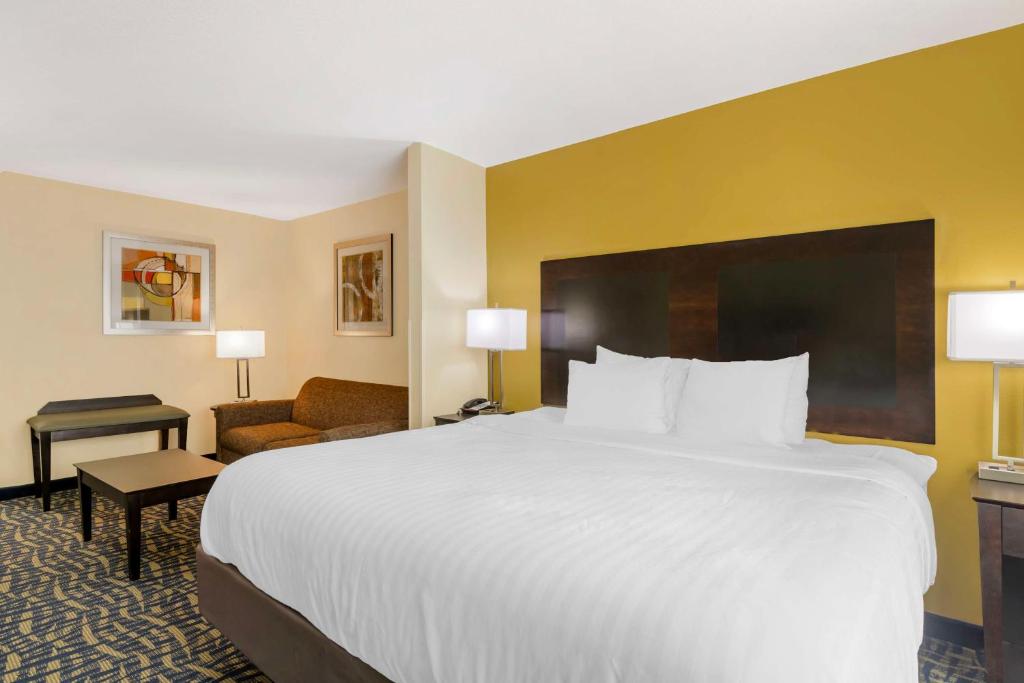 a hotel room with a large white bed and a chair at Best Western Plus Brunswick Inn & Suites in Brunswick