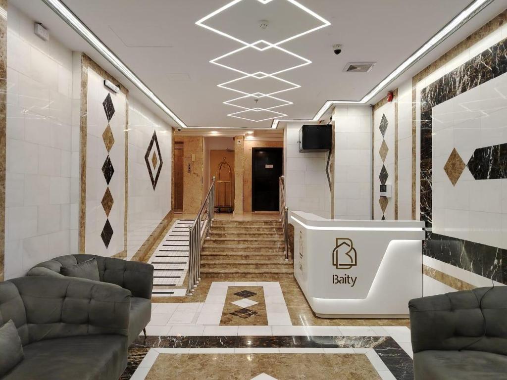 a lobby with stairs and a tub in a building at فندق العز بيتي in Al Madinah