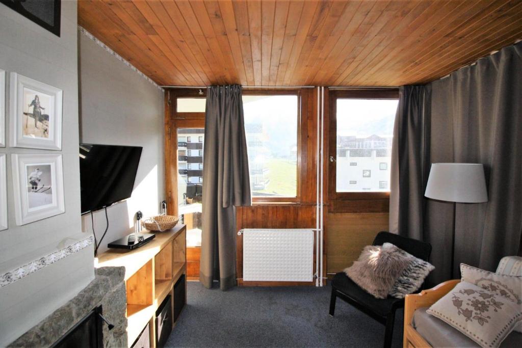 a living room with a large window and a television at Résidence Roches Rouges A - 2 Pièces pour 4 Personnes 971 in Tignes