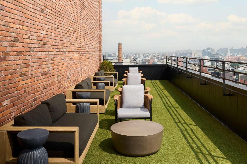 une rangée de chaises et de tables sur un toit dans l'établissement Arlo Williamsburg, à Brooklyn