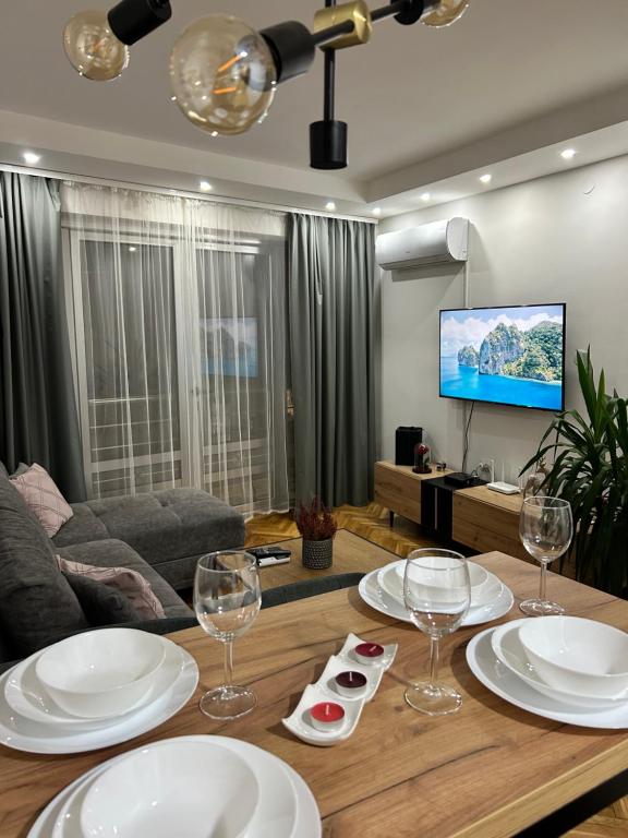 a living room with a table with plates and wine glasses at House Inn in Pirot