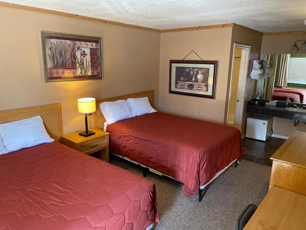 ein Hotelzimmer mit 2 Betten und einem Waschbecken in der Unterkunft Whitney Portal Hotel And Hostel in Lone Pine