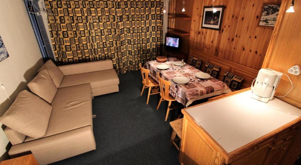 sala de estar con mesa y sofá en Résidence Palafour - Studio pour 4 Personnes 221 en Tignes