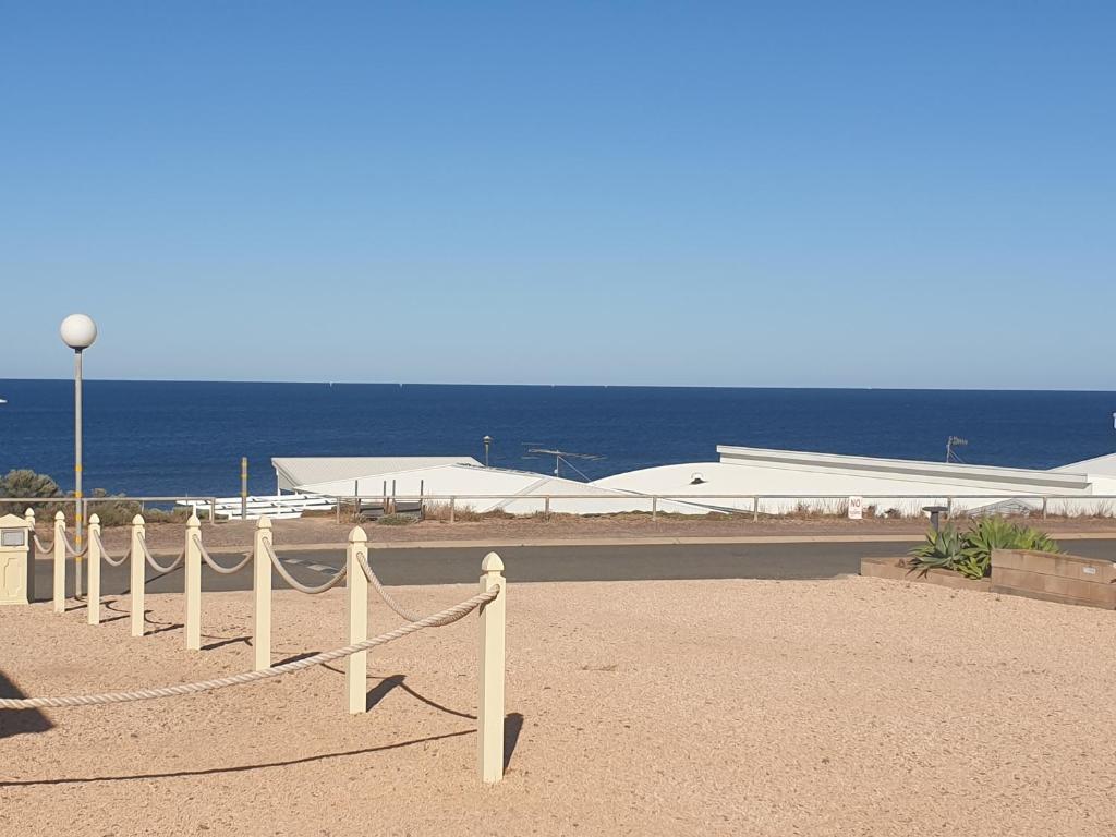 a fence in front of the ocean with a building at Wallaroo Sea View home in Wallaroo