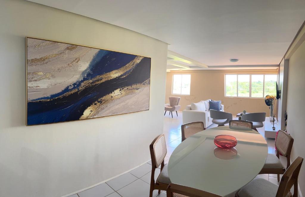 Cobertura,conforto e localização في خوازيرو دو نورتي: غرفة معيشة مع طاولة و لوحة على الحائط