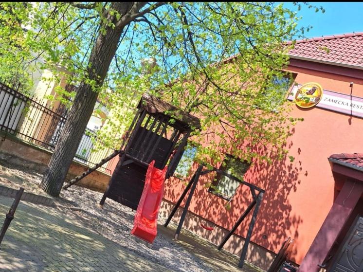 una bolsa roja está en una puerta frente a un edificio en Penzion Nové dvory en Kutná Hora
