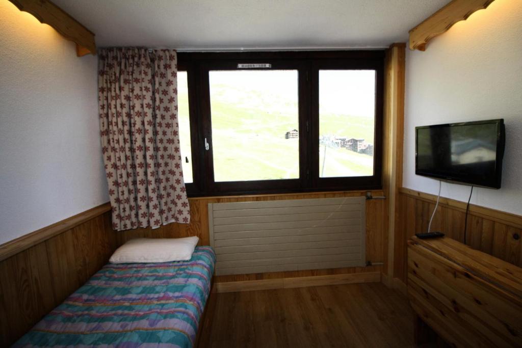 a small room with a bed and a tv and a window at Résidence Palafour - Studio pour 2 Personnes 371 in Tignes