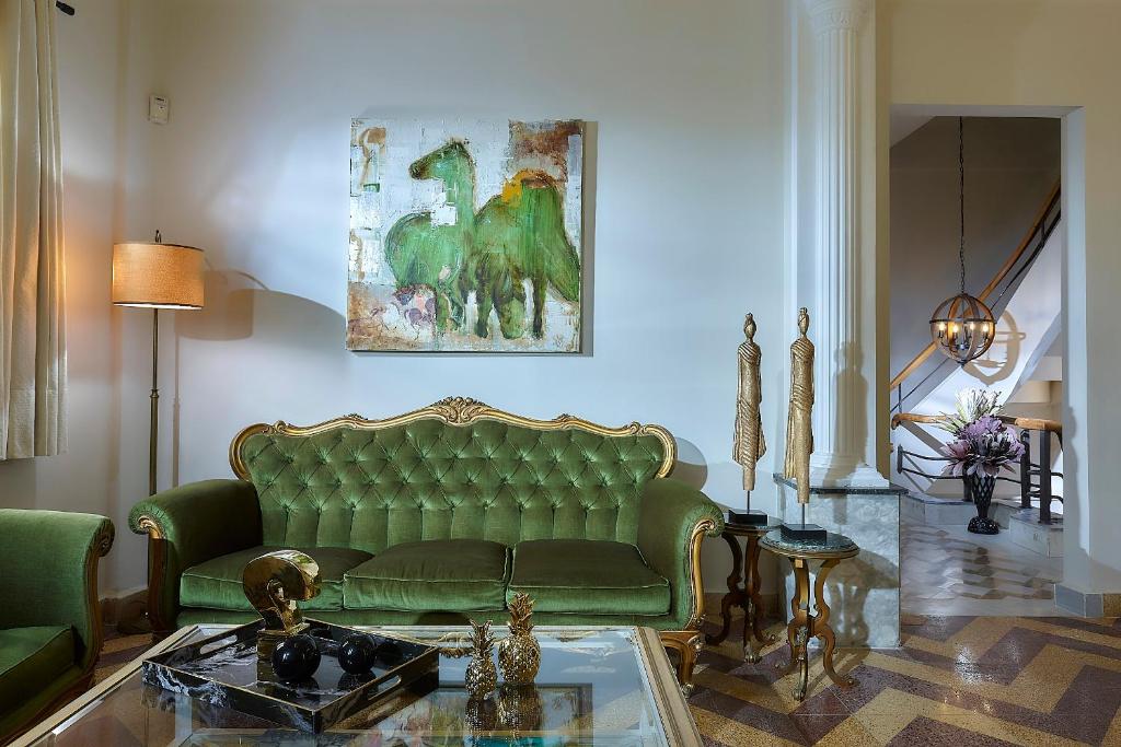 a living room with a green couch and a table at Erato Vintage House (city center) in Heraklio Town
