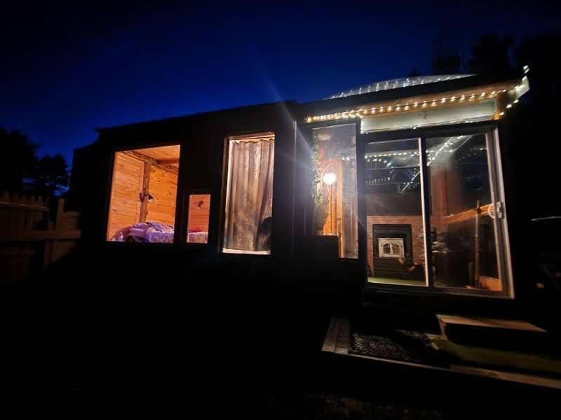 una pequeña casa con luces encendidas por la noche en The Dome house near Hunter and Hudson, en Catskill