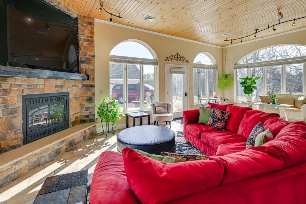 uma sala de estar com um sofá vermelho e uma lareira em Large Home with Indoor Basketball Court and Game Room! em Wisconsin Dells