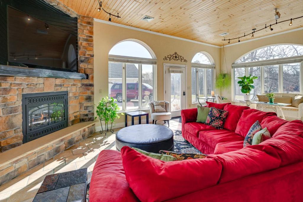a living room with a red couch and a fireplace at Large Home with Indoor Basketball Court and Game Room! in Wisconsin Dells