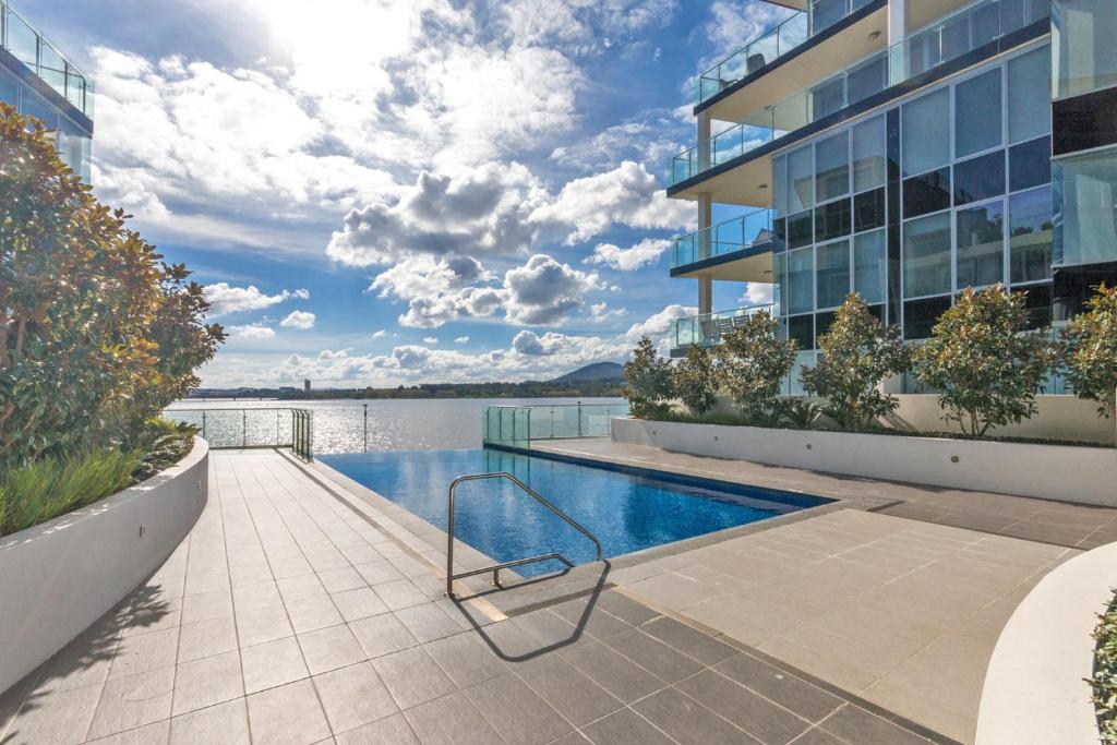 a swimming pool in a building with a view of the water at Lakeside 1-Bed with Courtyard Pool Gym & Parking in Kingston 