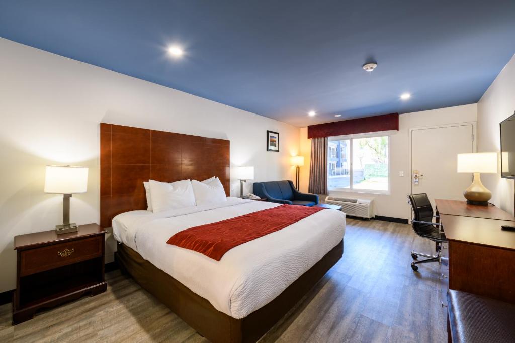 um quarto de hotel com uma cama grande e uma secretária em Hyland Inn near Pasadena Civic Center em Pasadena