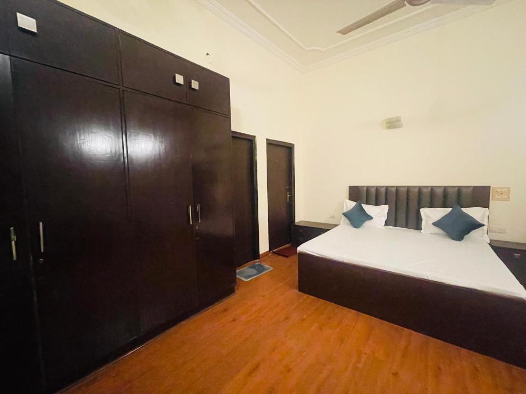 a bedroom with a bed and a large cabinet at Own stay Chhaterpur in New Delhi