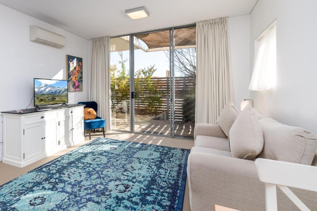 a living room with a white couch and a blue rug at Exquisite Apartment with BBQ and Pool, near Shops in Phillip
